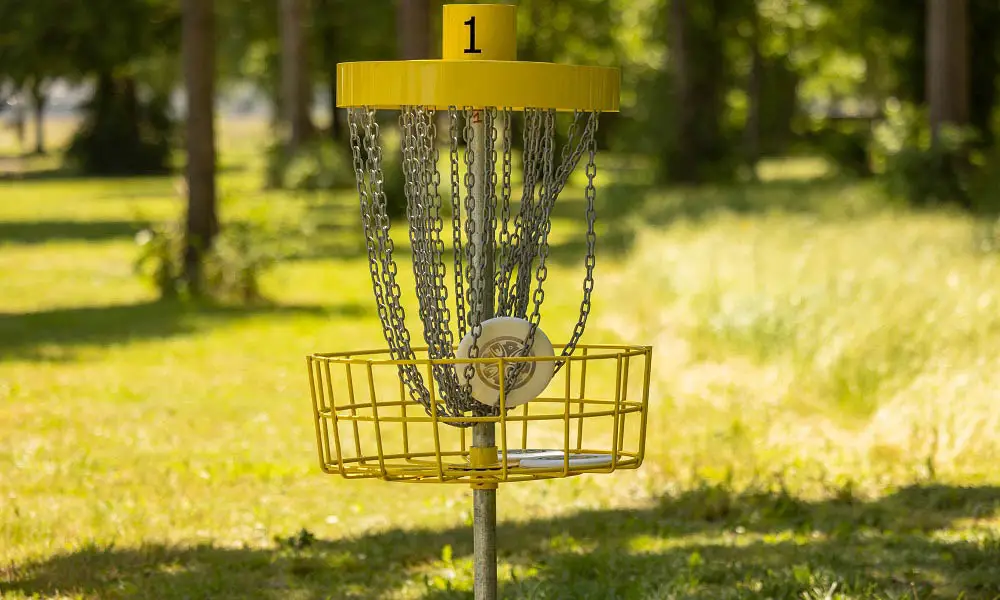 A disc lands in the Hole 1 basket on the Chemeketa disc golf course